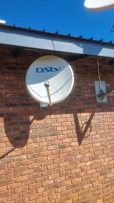 DStv satellite dish on brick facade - angle view