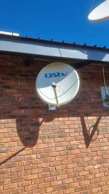 DStv satellite dish professional installation on brick wall